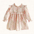 Blush floral dress with ruffled bib detail, front view