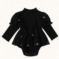 Black romper with textured bodice and puffed sleeves, front view