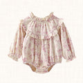 Cream romper with blush floral print and ruffle bib, front view