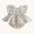 Cream romper with botanical print and tiered flared skirt, front view