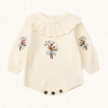 Knit romper with embroidered floral bouquet and crochet collar, front view