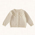 Cream knit cardigan with pom-pom embroidery, front view