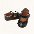 Black patent baby shoes with bow and scalloped trim, front view