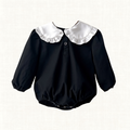 Black romper with oversized ivory ruffled collar and long puff sleeves, front view